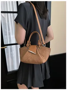 Detailansicht der stilvollen braunen Schultertasche mit strukturiertem Stoff und Metallverschluss.