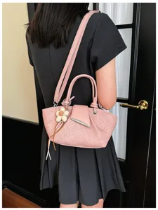 Detailansicht der modischen rosa Umhängetasche mit Blumenanhänger, ideal zum Pendeln.
