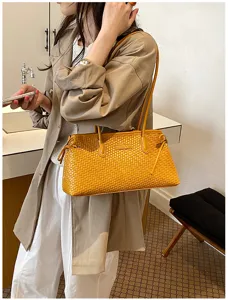 Vista detallada del bolso de hombro tejido amarillo, elegante diseño bajo el brazo, accesorio chic.