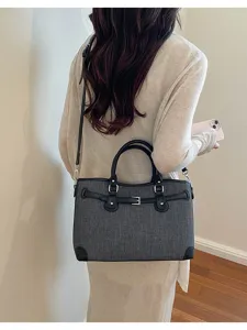 Detail view of the stylish commuter handbag with black leather trim and belt decoration.