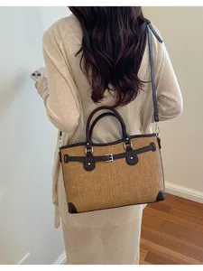 Detailed shot of casual canvas shoulder bag with leather trim, versatile daily commuting tote.