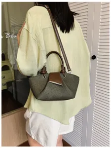 Detailansicht der stylischen minimalistischen grünen Umhängetasche mit braunen Lederdetails.