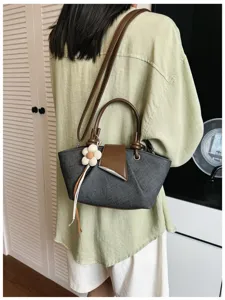 Detailansicht der stylischen Freizeittasche mit Schultergurt und schickem Blumenanhänger.