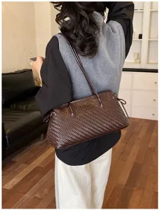 Vista detallada del bolso de hombro de cuero tejido marrón oscuro, elegante bolso para mujer.