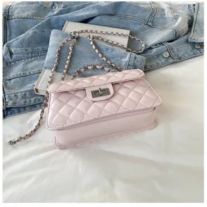 Detail view of pink quilted shoulder bag featuring metallic chain strap and turn-lock closure.