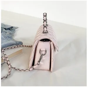 Side detail view of a pink quilted shoulder bag with chain strap and elegant hardware.