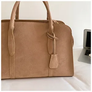 Vintage suede boston handbag detail view, elegant camel tote bag showing soft texture and handles.