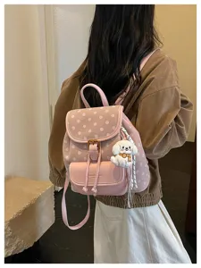 Pink polka dot backpack detail showing stylish design, soft material and cute dog pendant.