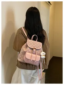 Pink polka dot backpack detail showing front pocket and cute puppy charm for daily casual style.