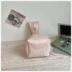 Detailansicht der minimalistischen rosa gefalteten Handgelenk-Eimertasche mit Henkel.
