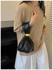 Detailansicht der trendigen gerafften schwarzen Handgelenktasche mit goldenem Ring.
