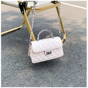 Outdoor detail view of a chic pink quilted chain shoulder bag featuring metal twist lock.