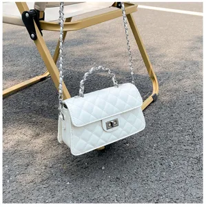 Detail shot of the quilted chain crossbody bag displayed outdoors on a folding chair.