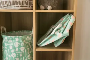 Gedetailleerd overzicht van de opvouwbare stoffen opbergmand netjes op houten plank.