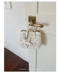 Borsa a secchiello a tracolla bianca traforata con ciondolo a stella chic e manico rétro.