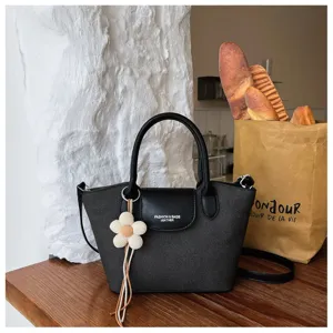 Chic black dumpling handbag for women, stylish minimalist shoulder tote bag with floral charm.