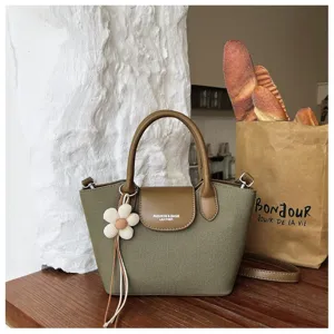 Korean niche design canvas handbag with leather details and cute flower charm for daily wear.