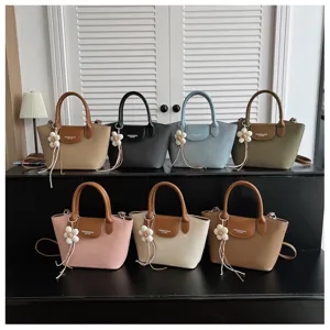 Detailed view of fashionable multi-color dumpling shoulder bags with cute flower pendants.