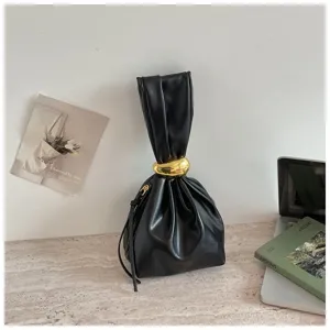 Detailansicht der minimalistischen Plissee-Handtasche mit schickem Goldring-Akzent.