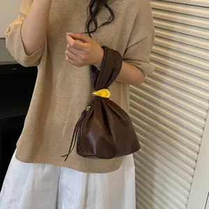 Stilvolle Damen Handtasche aus braunem Kunstleder mit trendigem Knotengriff und goldenem Metalldetail.