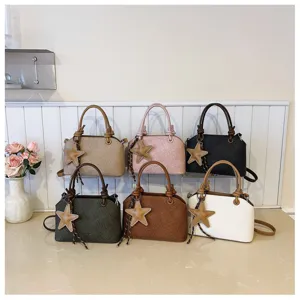 Nahaufnahme der stilvollen Handtaschen mit Sternanhängern und schicken Knoten-Griffen.