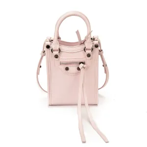 Petit sac bandoulière rose en cuir, pochette de téléphone tendance style moto avec clous et anses.