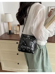 Detailed view of a stylish black quilted chain shoulder bag with metal stud accents.