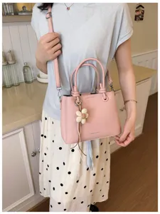 Vista detallada de bolso bandolera rosa de cuero PU para mujer con bonito colgante floral.