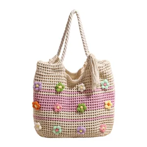 Casual handmade crochet tote bag with colorful floral appliques and braided handles.