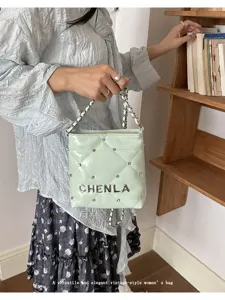 Close-up detail of the light green quilted shoulder bag with chic chain strap and metal decor.