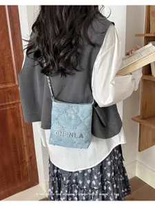 Denim quilted crossbody bag with metal studs and chain strap lifestyle detail view showcase.