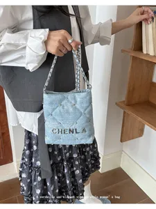 Denim quilted chain shoulder bag detail showing texture and metal chain strap design.