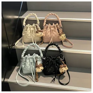 Stylish women quilted bucket bag with braided handle, crossbody strap and bear pendant.