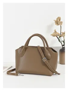 Detail view of the retro brown leather commute handbag showing fine texture and hardware.