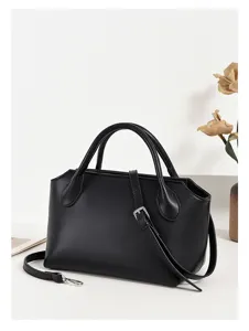 Detailed view of the black leather handbag, showing exquisite metal buckles and fine texture.