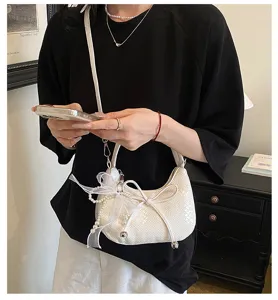 French woven crescent underarm bag detail, featuring elegant bow and pearl pendant design.