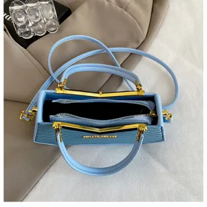 Elegante borsa a mano celeste con dettagli dorati, design chic con chiusura a bacio.