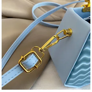 Primo piano dettagliato della borsa a tracolla da donna con parti metalliche eleganti.