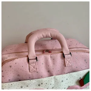 Close-up detail of a pink star pattern travel duffel bag showcasing the reinforced handle.
