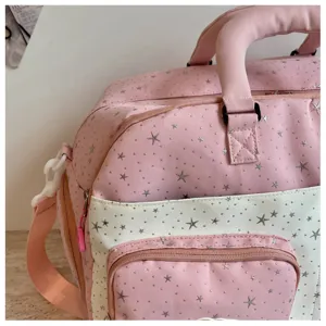 Detailed view of pink star print travel duffel bag, showing fabric texture and sturdy handle.