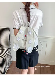 Vue détaillée du charmant sac à dos en toile avec des rabats d'oreilles et des des patchs d'étoiles.
