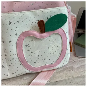 Detailed view of the pink star pattern casual crossbody bag with a cute apple pocket.