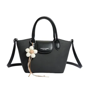Black dumpling handbag for women, chic crossbody bag with cute flower charm pendant design.