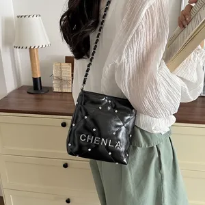 Black quilted chain shoulder bag with metallic letter design and rhinestone studs for women.