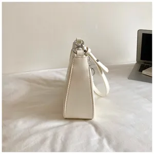 Minimalist cream white leather underarm shoulder bag with chic metal rings for daily wear.