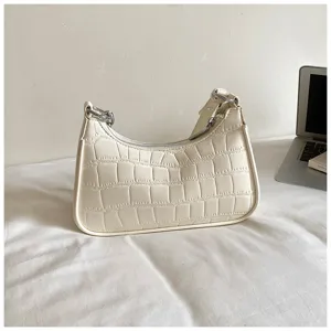 Detailed view of the stylish cream white crocodile pattern shoulder baguette bag, chic minimalist design.