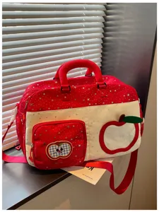 Red white duffel bag detail, starry pattern, front apple pocket, casual travel bag close-up.
