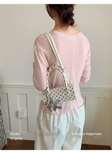 Vue détaillée du sac à épaule cylindrique à pois élégant avec un charmant pendentif étoile.