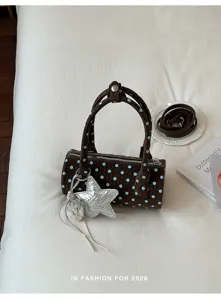Sac à main cylindrique tressé marron chic avec des pois bleu clair et un pendentif étoile argenté.