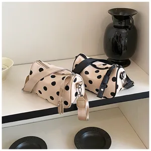 Chique stippen cilinder schoudertas met verstelbare riem en minimalistisch ontwerp.